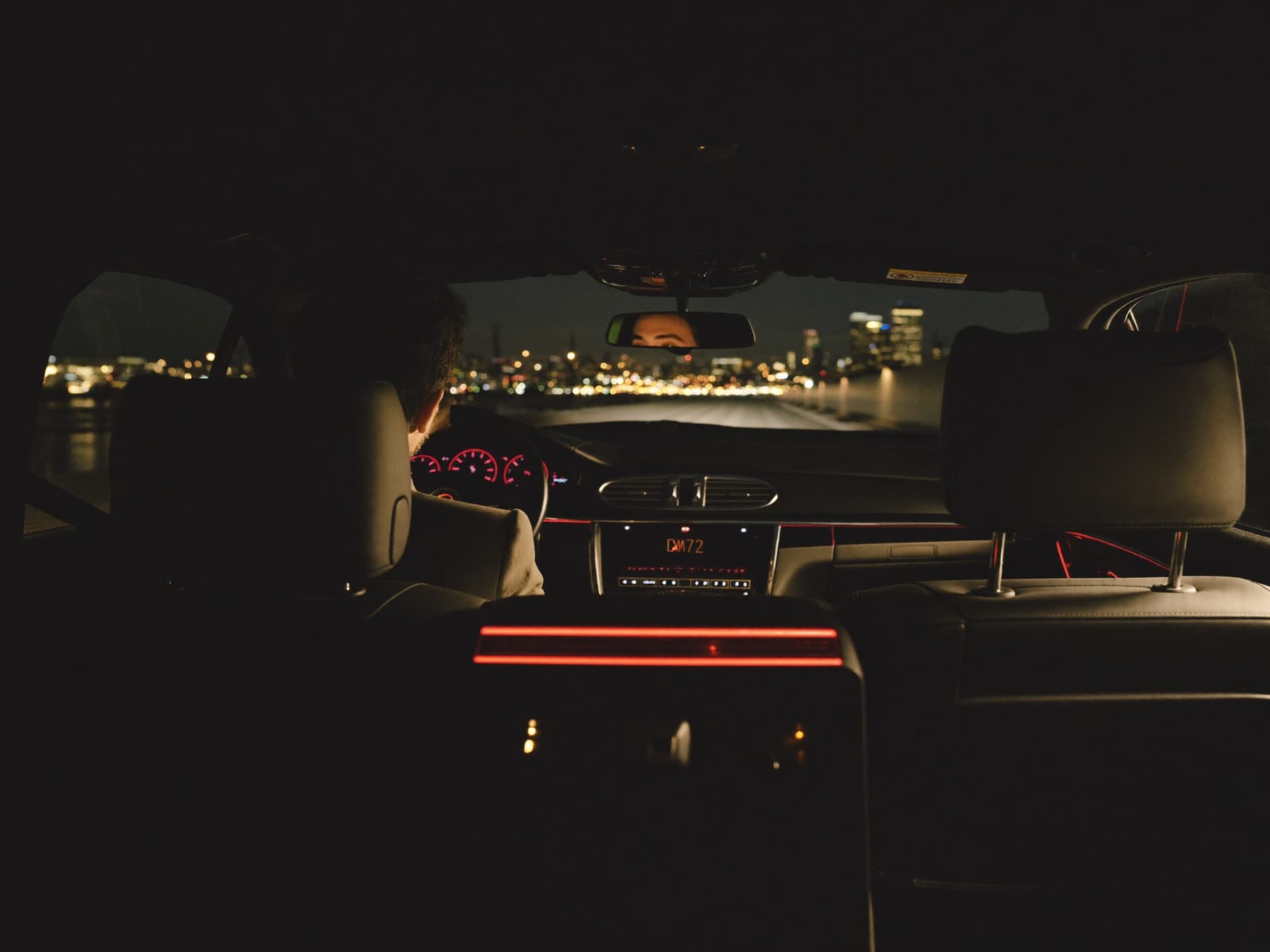 Business traveller looking at the Montreal skyline from the back seat of a chauffeured sedan